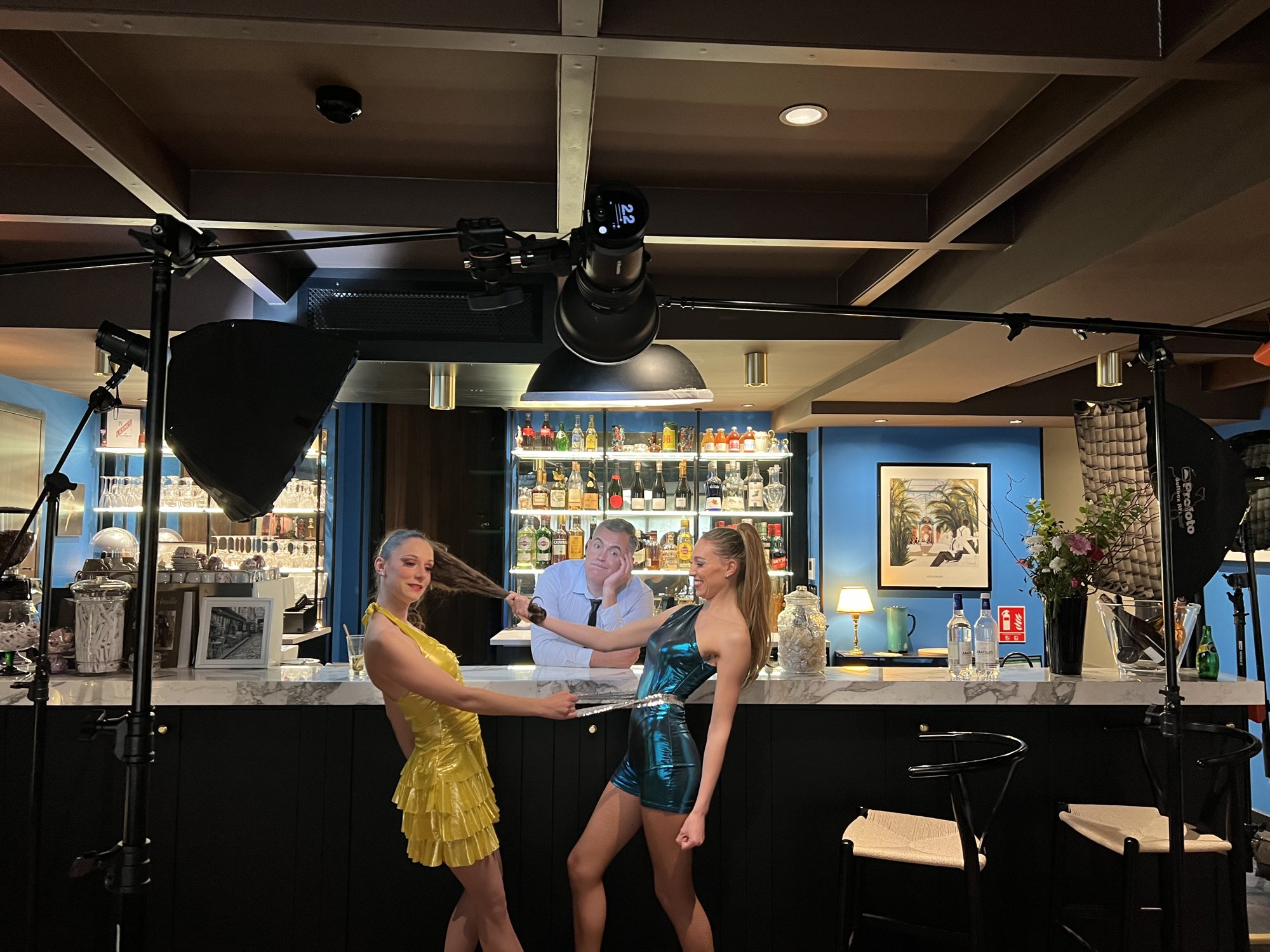 Installation des éclairages autour des trois artistes au bar pendant le shooting